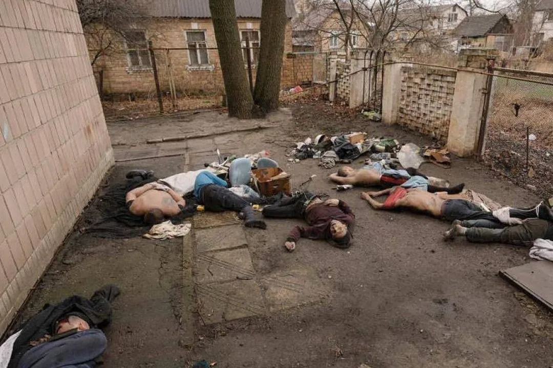 Bodies of executed civilians in a courtyard in Bucha. Several men lie on the ground with signs of violent death.