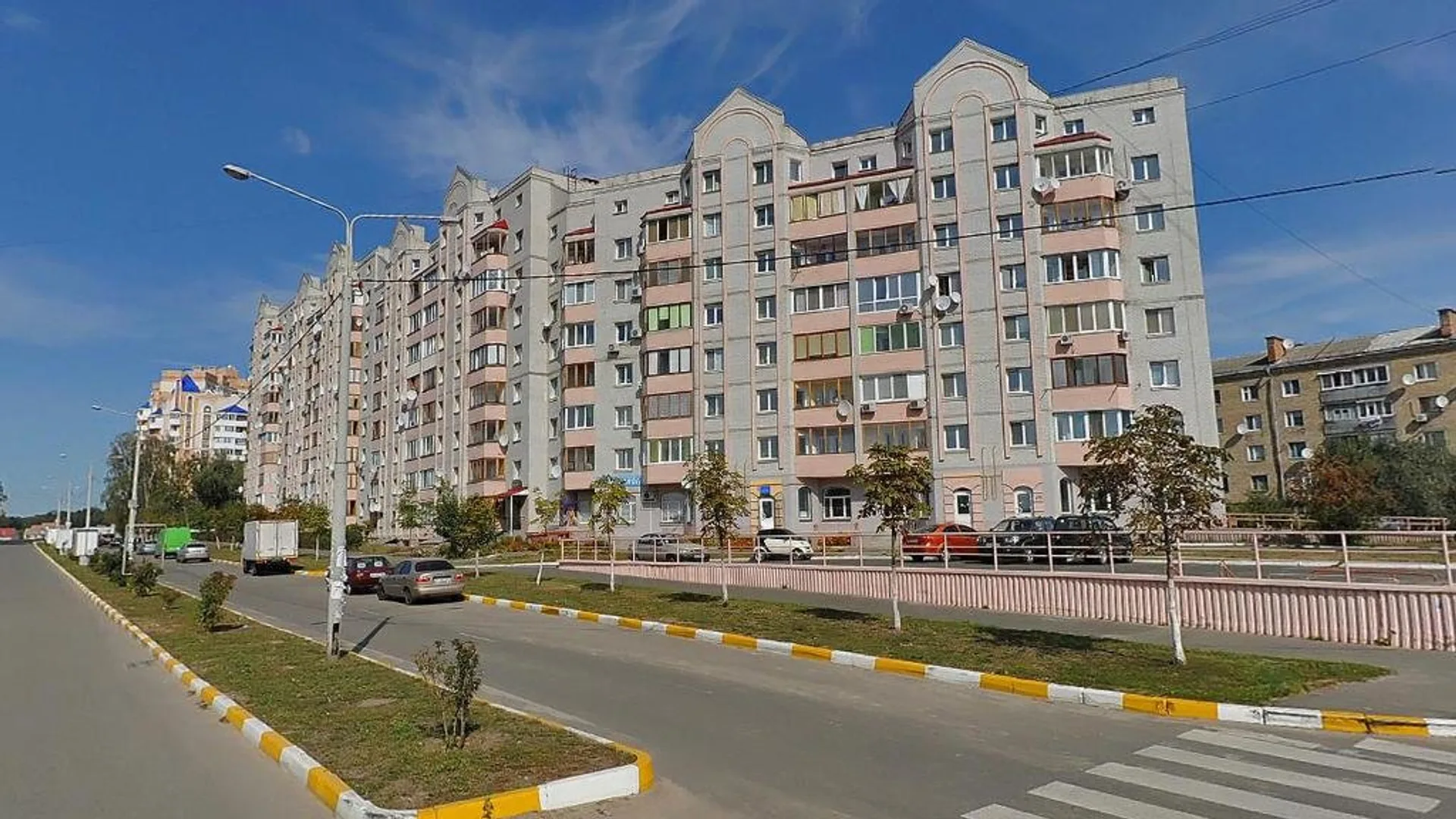 A residential neighborhood in Bucha in peacetime before the occupation: street, crosswalk, and apartment buildings.
